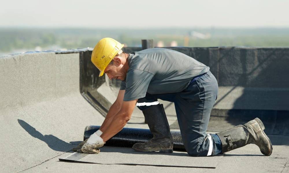 A man working on a roof with a hard hat.